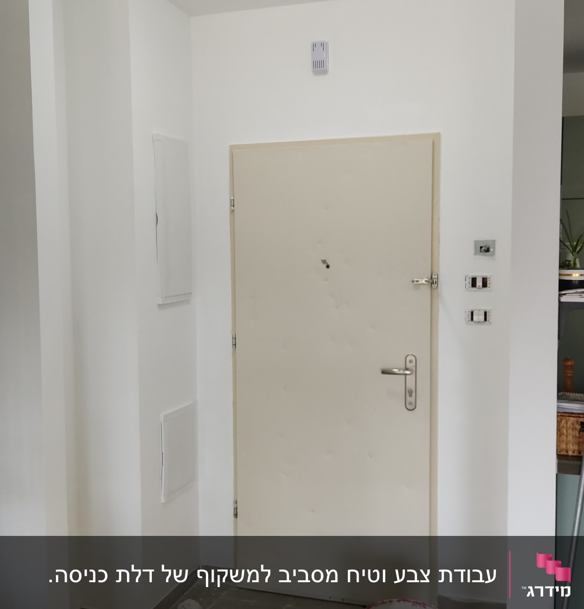 דלת לבנה עם דלי צבע ומברשת על הרצפה